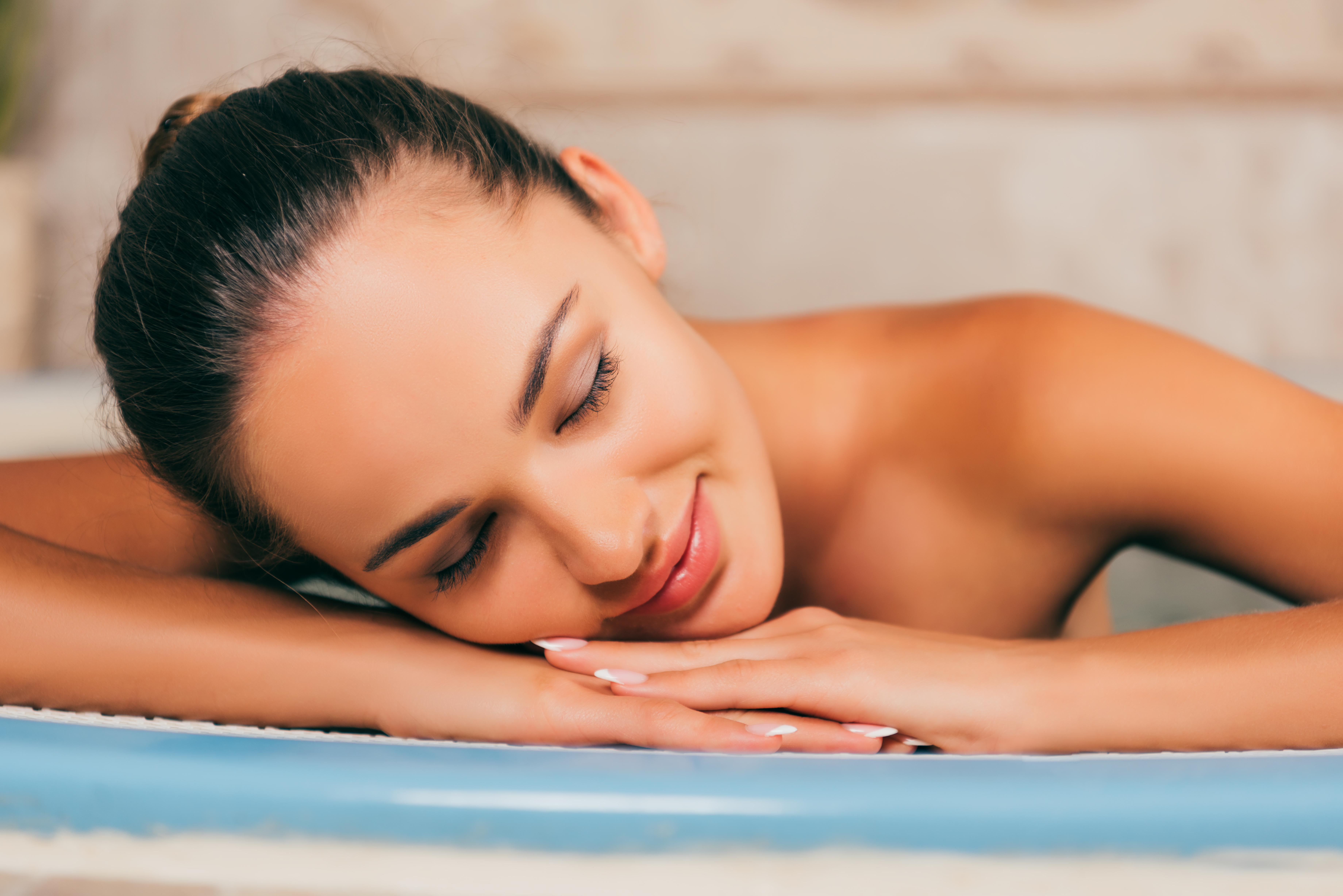 woman relaxing with closed eyes at spa salon